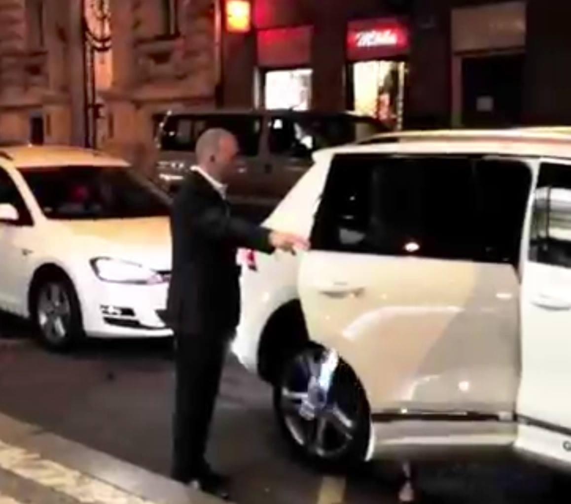 Close protection operative beside a client vehicle